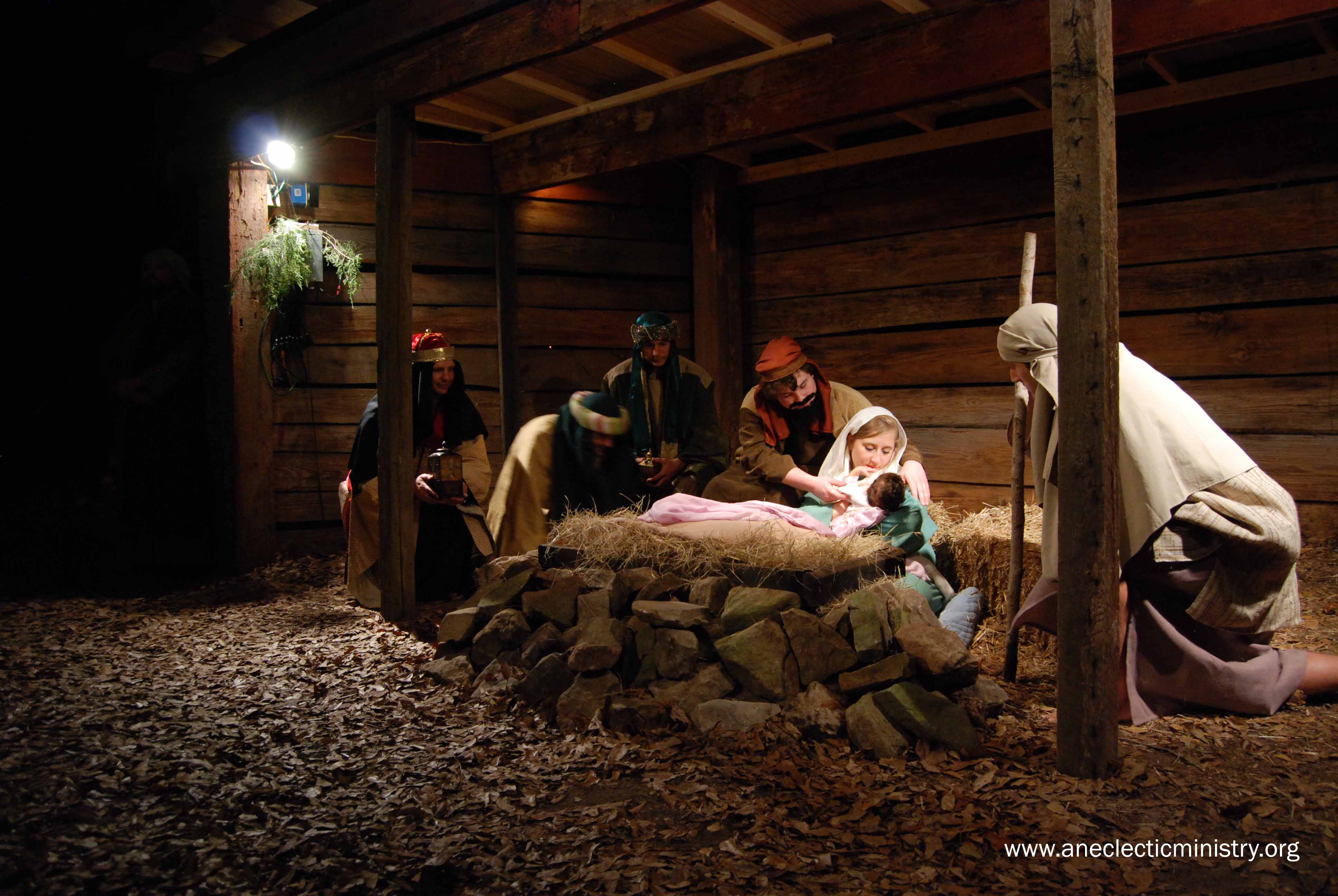Joseph, Mary, and Jesus in the manger with shepherds
